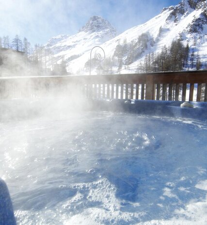 Bubbling hot tub overlooking snowy mountains 