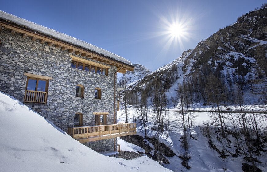Sunny snowy view of mountain behind contemporary ski chalet in Val d'Isere