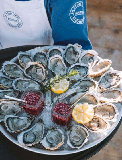 Fuitiere waiter holding plate of oysters 