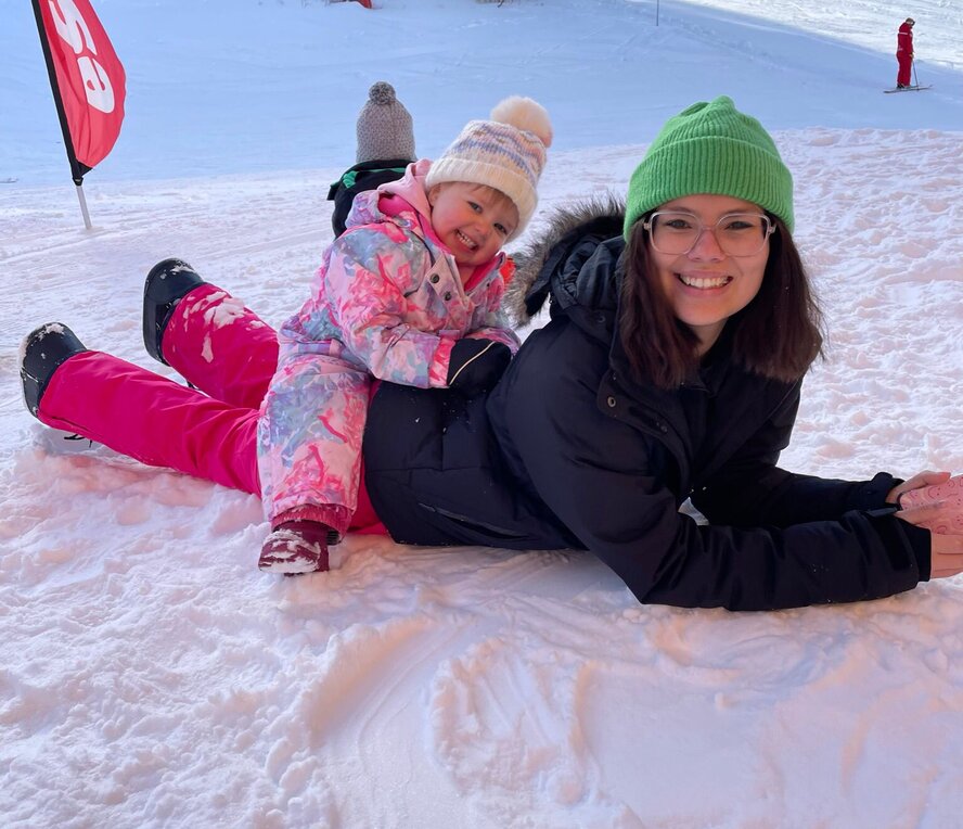 Private ski nanny with toddler, laying on the piste in Arc 1950