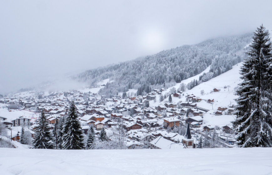 View of ski resort village from above on a snowy overcast day