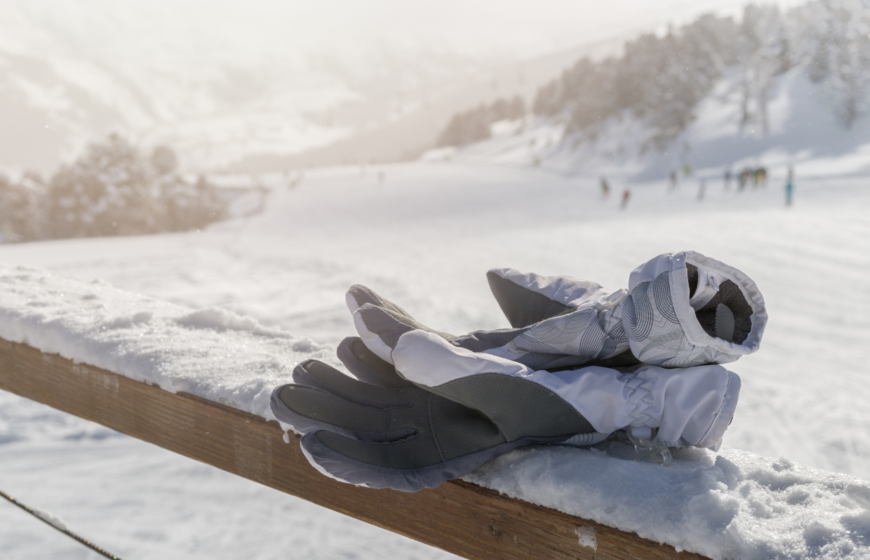 Pair of ski gloves resting on terrace of ski restaurant