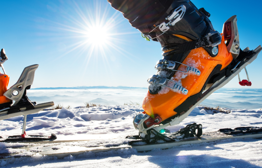 Ski touring skis and boots with sun flare in background