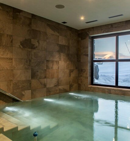 Indoor swimming pool with view of snowy slopes in CLUB 21Forty in Arc 2000