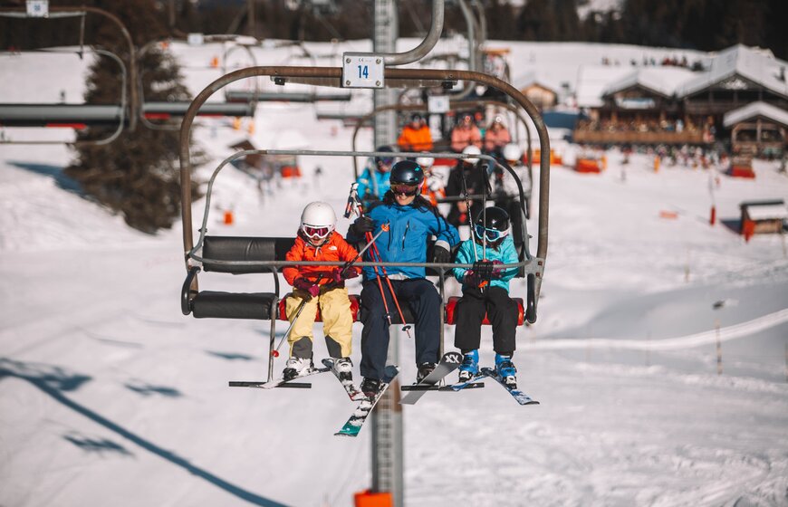 Adult and two young children on chairlift in Morzine