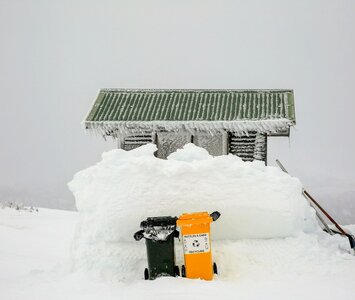 Recycle bins in the snow above ski lift