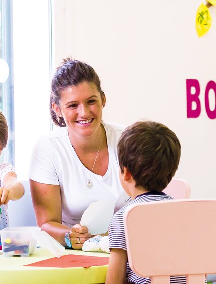 Nanny doing arts and crafts with young children