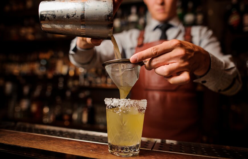 Cocktail being poured into tumbler