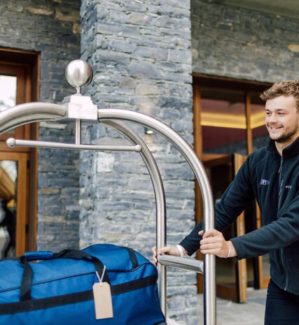 VIP SKI staff member pushing luggage trolley outside Bear Lodge ski hotel