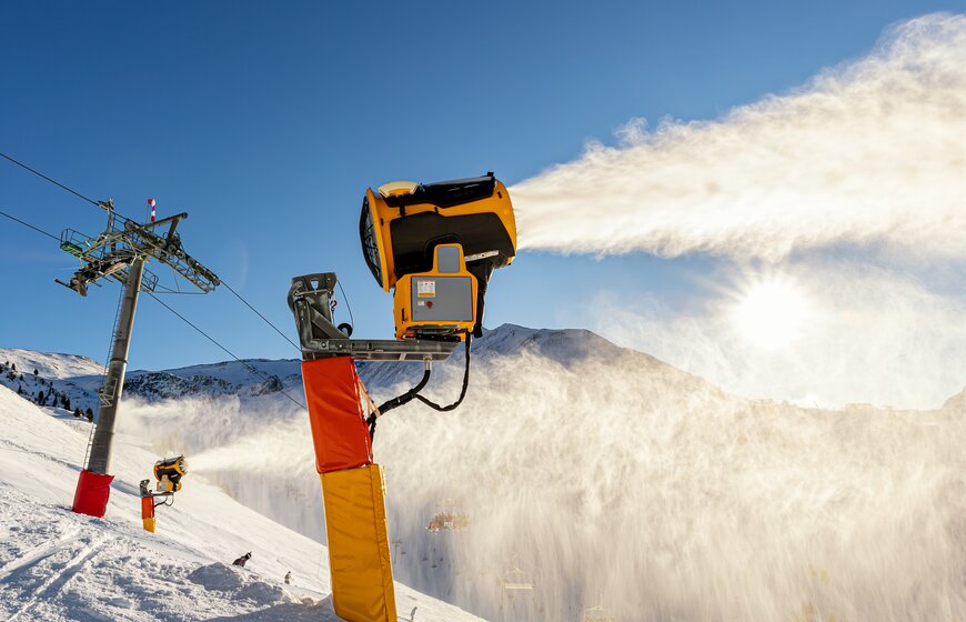 Snow cannon making snow on ski slope on cold wintery day