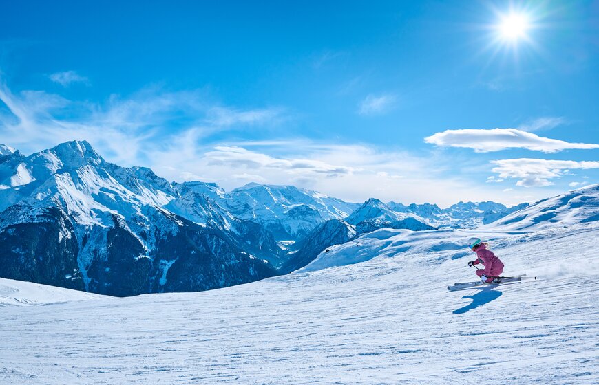 Female skier carving down ski slope