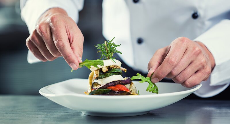 chef adding garnish to a plate