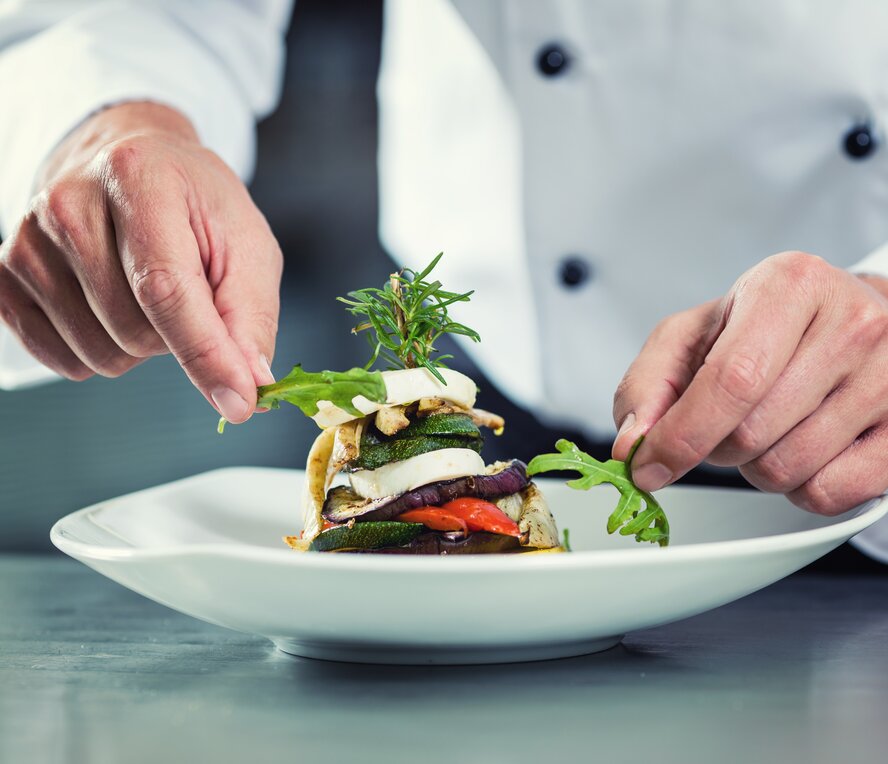 chef adding garnish to a plate