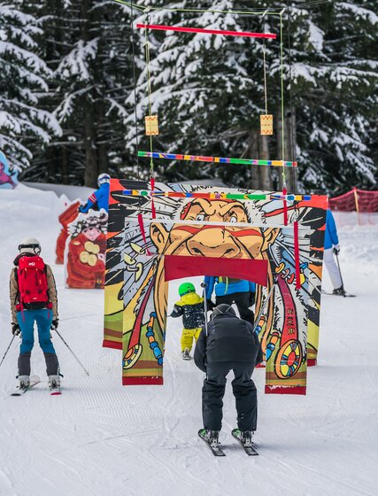 Family skiing through children's fun zone in La Plagne