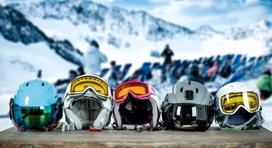 e ski helmets with goggles on a table