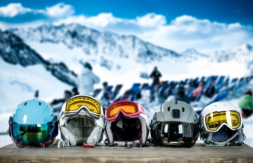 e ski helmets with goggles on a table