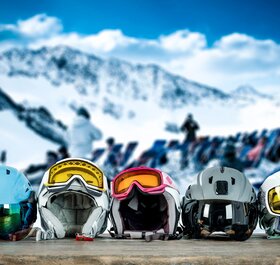 e ski helmets with goggles on a table