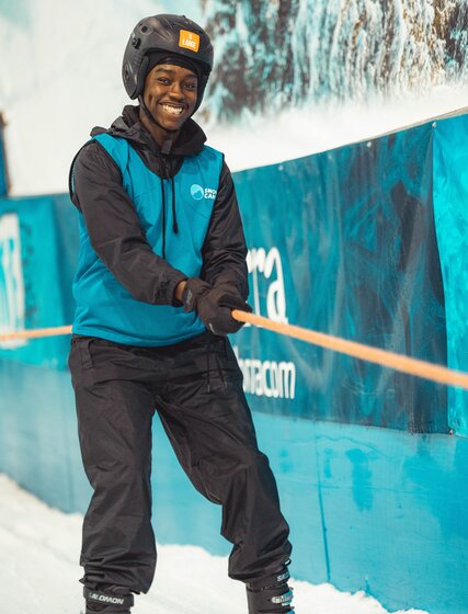 Smiling young boy holding on to rope tow at indoor snow centre