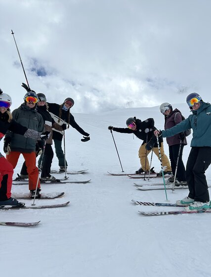 7 of the VIP SKI UK sales team smiling on skis and snowboards in Val d'Isere