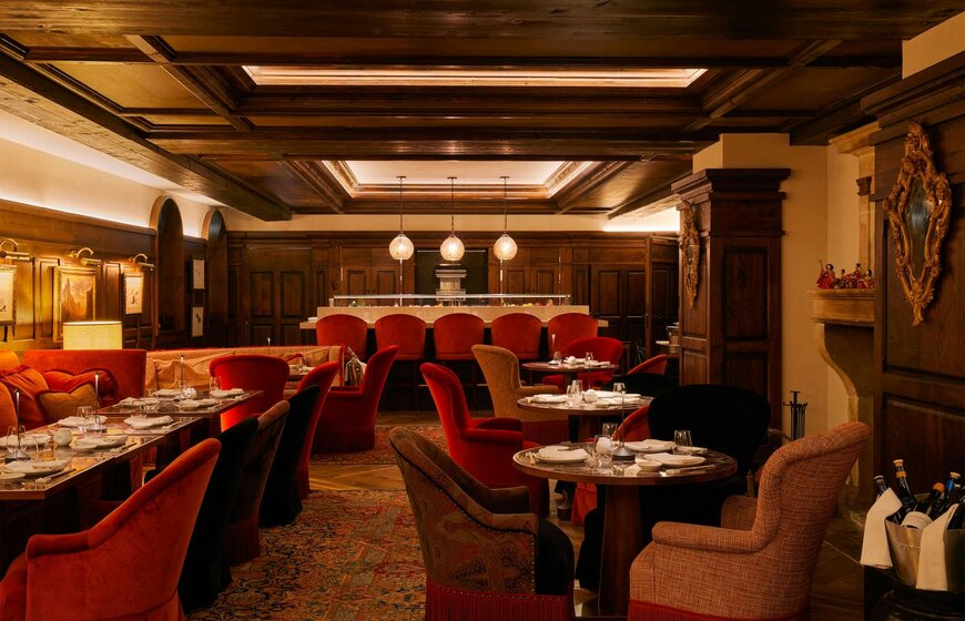 Red velvet dining chairs in moody elegant Matsuhisa restaurant in Val d'Isere