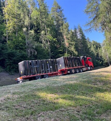 Hot tubs on back of lorry being driven up mountain road to La Plagne