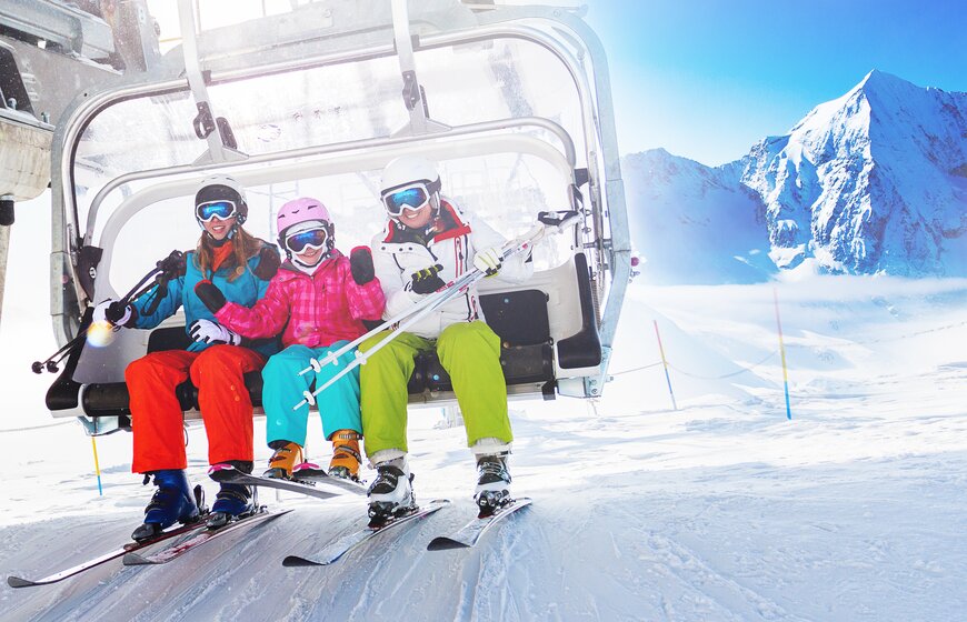 Two women and a little girl about to get off chairlift