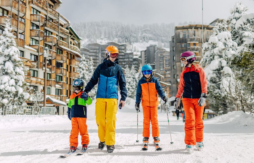 Family of four walking and skiing through snowy Avoriaz 