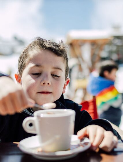 Young boy enjoying hot chocolate in Avoriaz