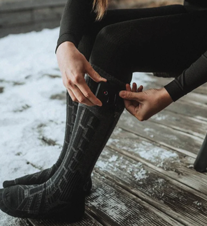 Woman turning on heated ski socks