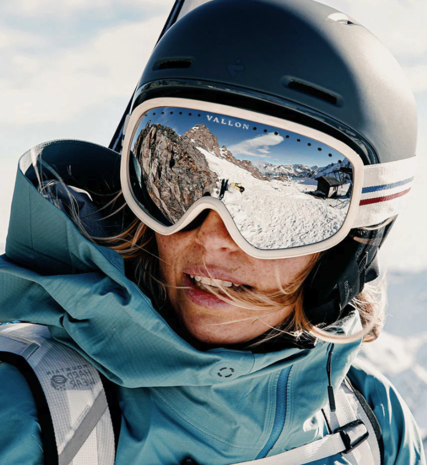 Female skier wearing Vallon white ski goggles and black helmet