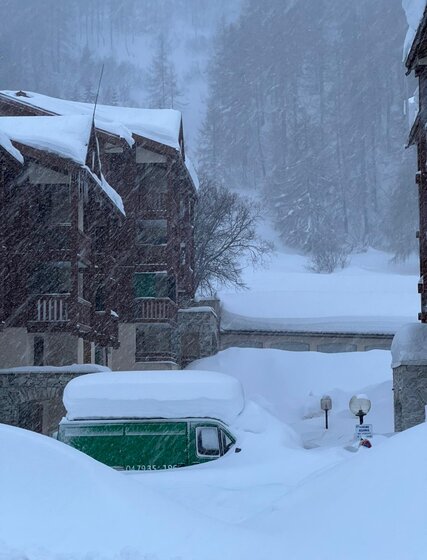 Green van covered in deep snow in Val d'Isere snowstorm