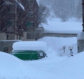 Green van covered in deep snow in Val d'Isere snowstorm