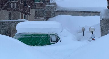 Green van covered in deep snow in Val d'Isere snowstorm