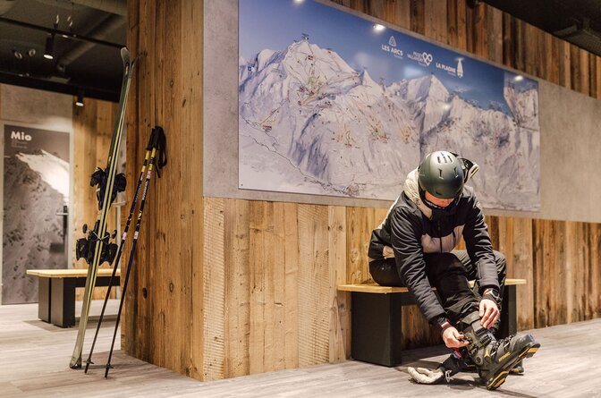 Male skier doing up ski boots in the VIP SKI Graciosa ski room in La Plagne