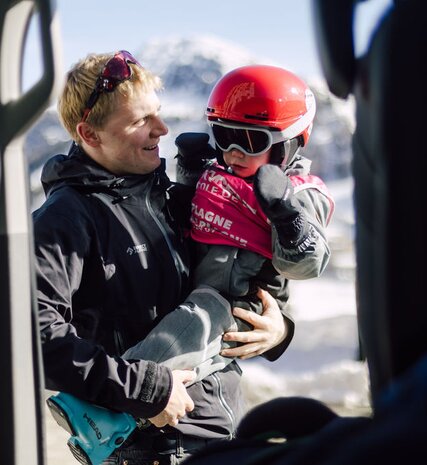 VIP SKI driver holding young child in ski gear