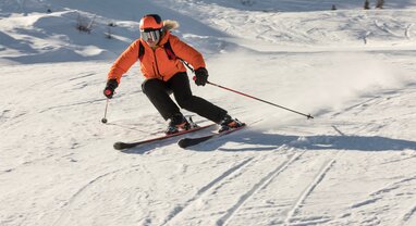 Woman skier carving down ski slope