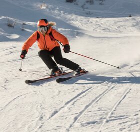 Woman skier carving down ski slope