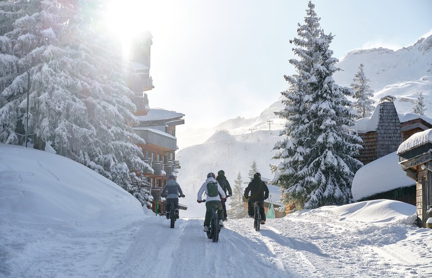 Four people cycling on fat bikes riding into Avoriaz