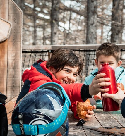Smiling children having drink and snack in the Village Perdu