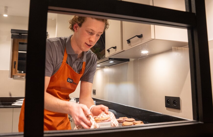 Male chalet host cooking dinner in kitchen