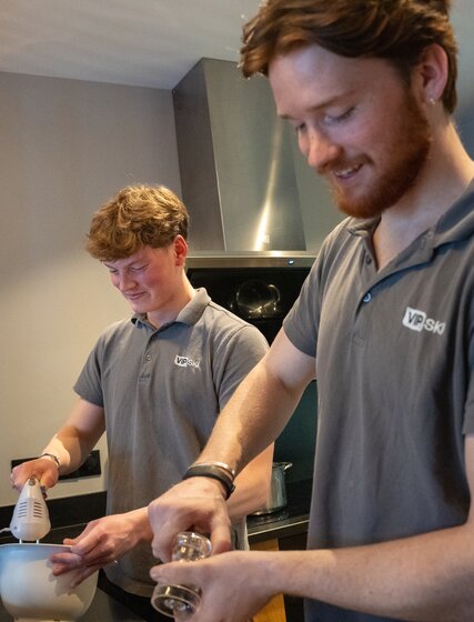 Two male chalet hosts cooking in a VIP SKI chalet kitchen