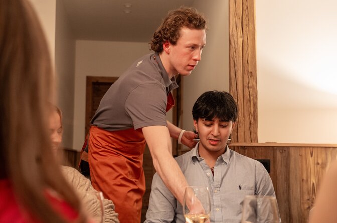 Male chalet host serving guests