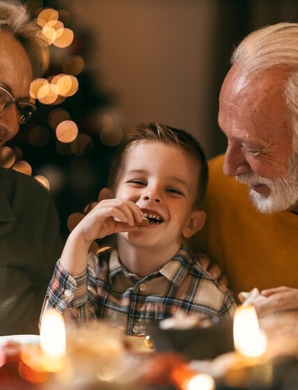 Smiling grandparents with little boy at Christmas