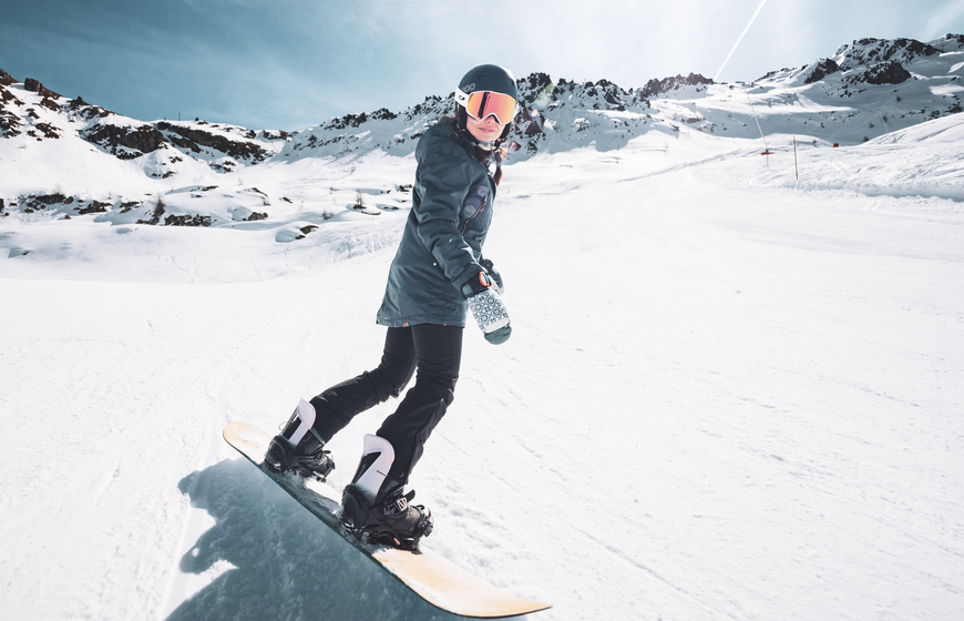 Female snowboarder descending empty slope in Les Arcs