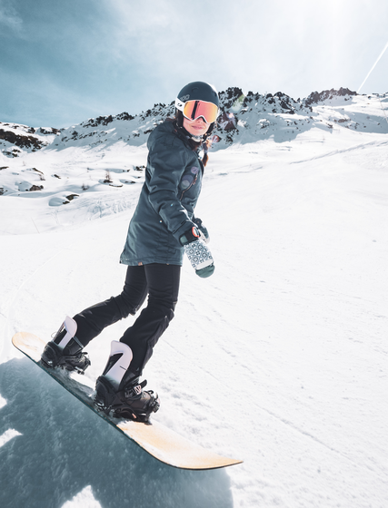 Female snowboarder on sunny empty ski slope in Les Arcs