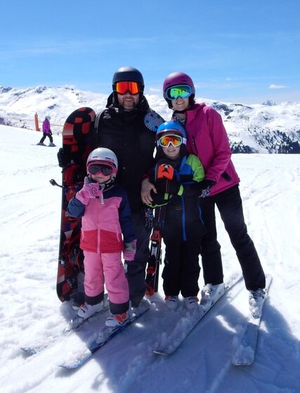 Family of four on snowy ski slopes