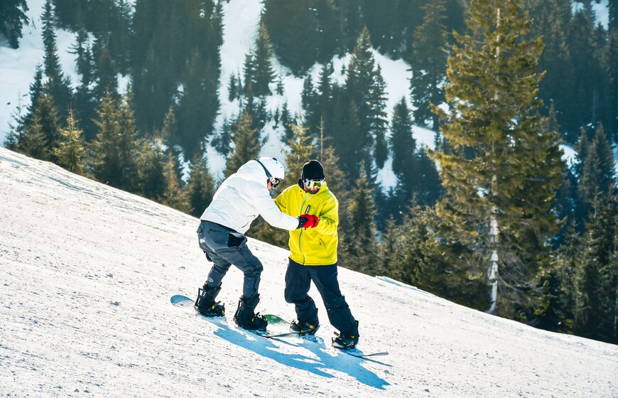 Beginner snowboarder having lesson with instructor