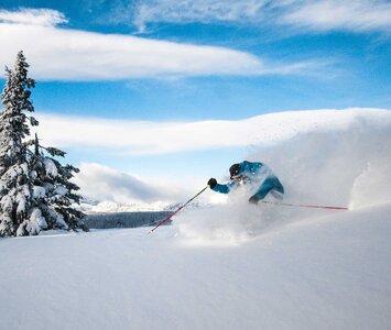 person skiing through powder snow 
