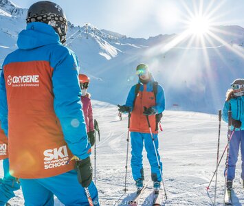 oxygene ski instructors snow covered mountain in background 