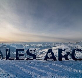 Les Arcs sign, large letters spelling the ski resort with snow covering